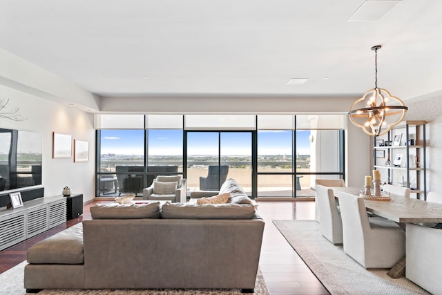 living room with light hardwood / wood-style floors, a wealth of natural light, and an inviting chandelier