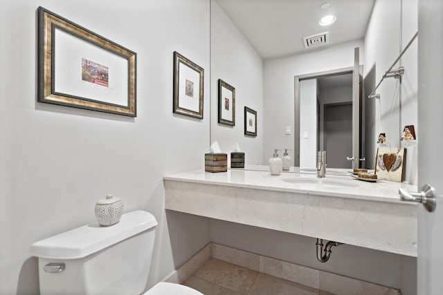 bathroom featuring toilet, vanity, and tile patterned flooring