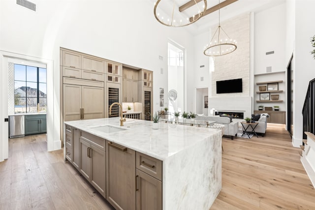 kitchen with a large island, sink, pendant lighting, a towering ceiling, and beam ceiling