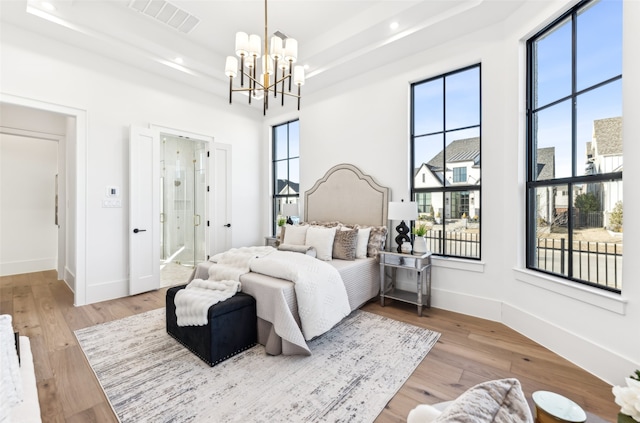 bedroom with a raised ceiling and multiple windows