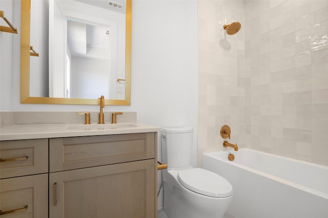 full bathroom featuring tiled shower / bath, vanity, and toilet