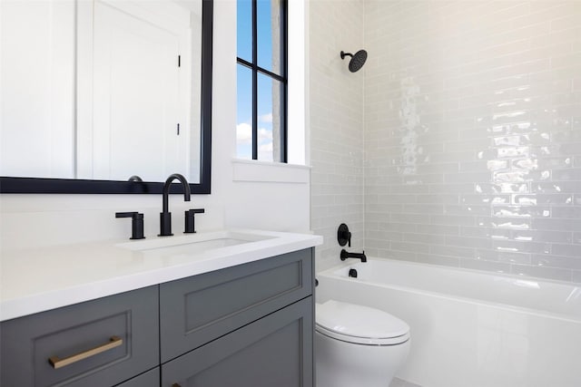 full bathroom with tiled shower / bath, vanity, and toilet