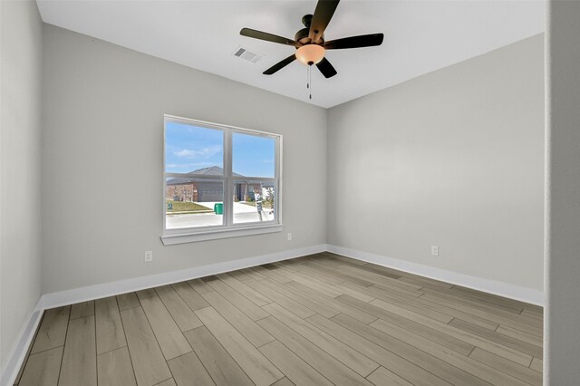 empty room with ceiling fan and light hardwood / wood-style floors