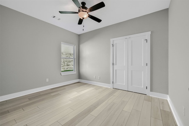 unfurnished bedroom featuring ceiling fan, a closet, and light hardwood / wood-style flooring