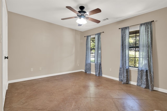 tiled spare room with a wealth of natural light and ceiling fan