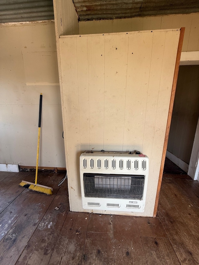 room details featuring hardwood / wood-style floors, heating unit, and wood walls