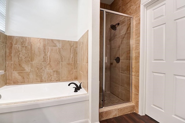 bathroom with independent shower and bath and wood-type flooring