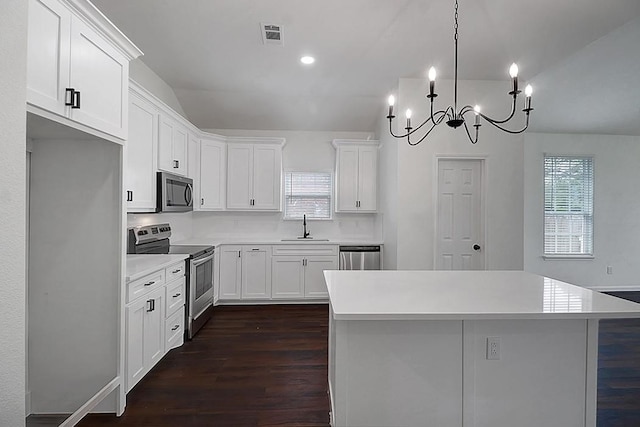 kitchen featuring white cabinetry, stainless steel appliances, dark hardwood / wood-style flooring, and a kitchen island