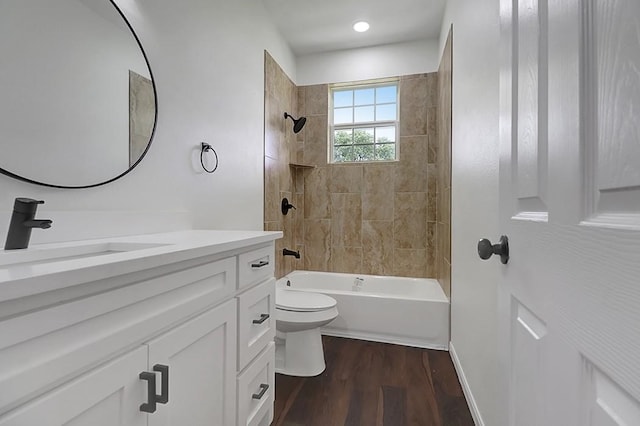 full bathroom with toilet, tiled shower / bath combo, vanity, and wood-type flooring