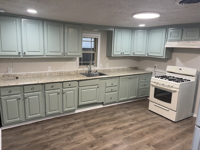 kitchen featuring dark hardwood / wood-style floors, white gas stove, sink, and a textured ceiling