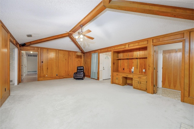 406 Rita Ln, Duncanville, TX 75116 - unfurnished living room featuring wooden walls, ceiling fan, light colored carpet, and a textured ceiling