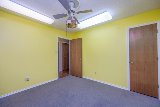 unfurnished bedroom with a skylight, ceiling fan, carpet, and a textured ceiling