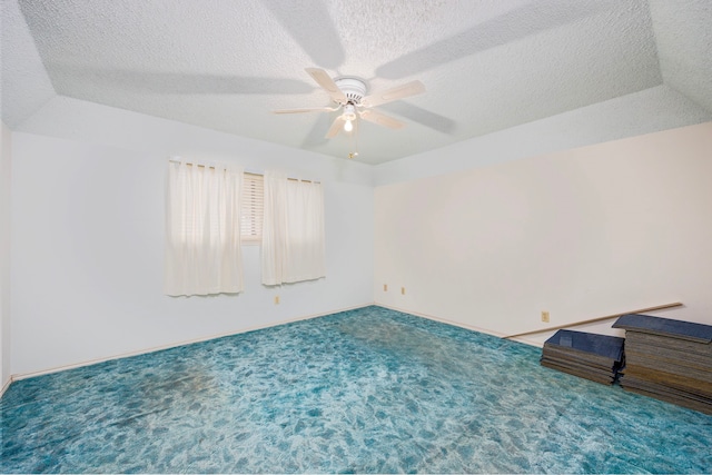 carpeted empty room with ceiling fan and a textured ceiling