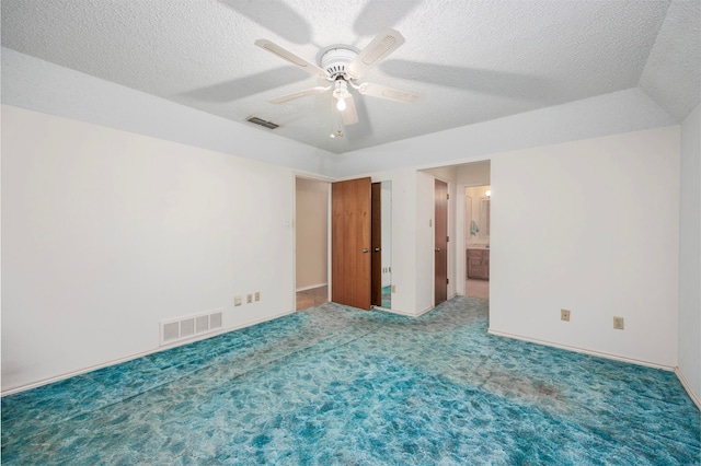 carpeted spare room featuring ceiling fan and a textured ceiling