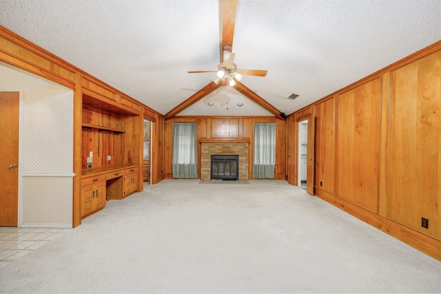 406 Rita Ln, Duncanville, TX 75116 - unfurnished living room featuring vaulted ceiling, a fireplace with flush hearth, a ceiling fan, a textured ceiling, and light colored carpet