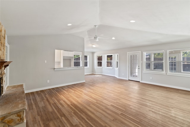 unfurnished living room with ceiling fan, lofted ceiling, light hardwood / wood-style flooring, and a fireplace