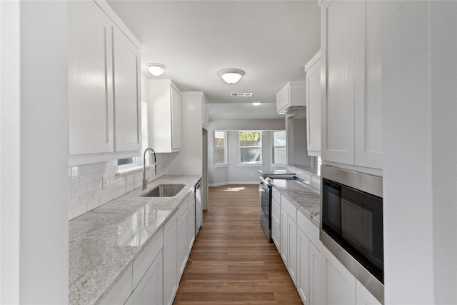 kitchen featuring white cabinets, sink, light stone counters, and stainless steel appliances