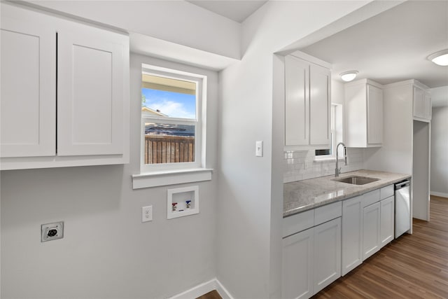 kitchen featuring decorative backsplash, white cabinets, light stone countertops, dishwasher, and sink