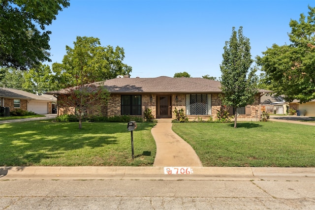 single story home featuring a front lawn and a garage