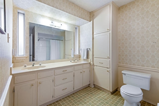 bathroom with vanity, toilet, and a textured ceiling