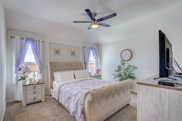 carpeted bedroom featuring multiple windows and ceiling fan