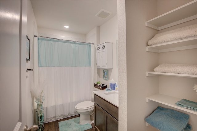 bathroom with toilet, vanity, and wood-type flooring