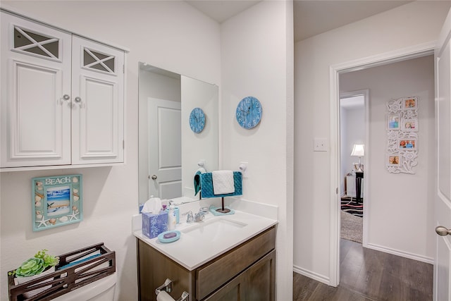 bathroom featuring vanity, hardwood / wood-style flooring, and toilet