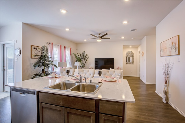 kitchen featuring ceiling fan, a kitchen island with sink, stainless steel dishwasher, dark hardwood / wood-style floors, and sink