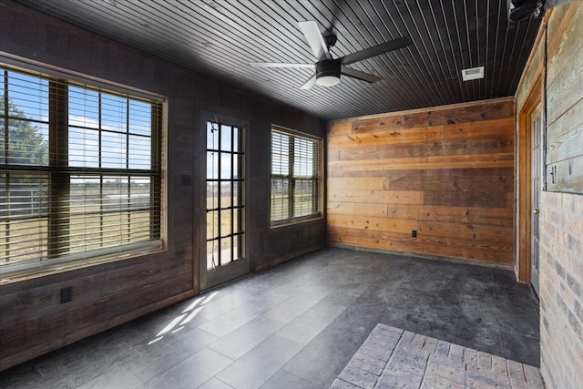 unfurnished room featuring ceiling fan, wood walls, and wooden ceiling