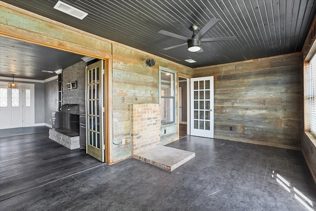 spare room with wooden walls, wooden ceiling, and ceiling fan