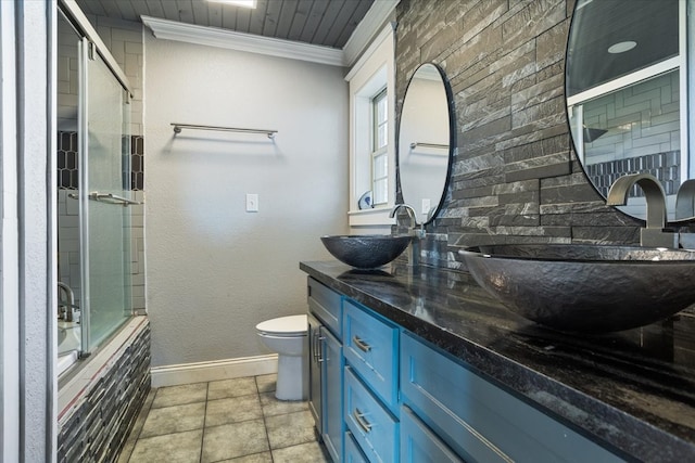 full bathroom featuring tile patterned floors, toilet, ornamental molding, bath / shower combo with glass door, and vanity