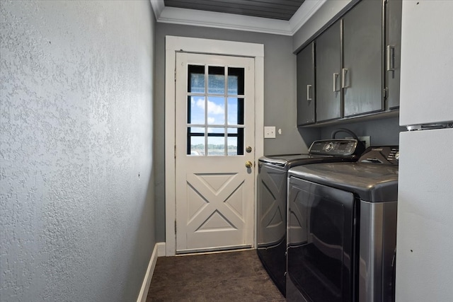 washroom with dark tile patterned floors, ornamental molding, washer and dryer, and cabinets