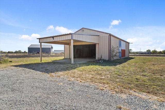 view of outdoor structure with a yard and a carport