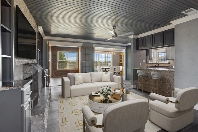 living room with hardwood / wood-style floors, ceiling fan, crown molding, and wooden ceiling