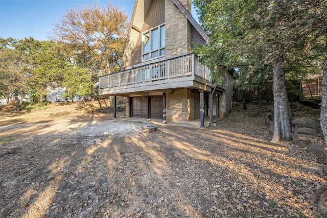 view of side of property featuring a wooden deck and a garage