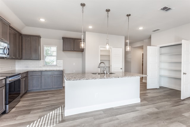 kitchen featuring sink, a kitchen island, stainless steel appliances, and light hardwood / wood-style floors