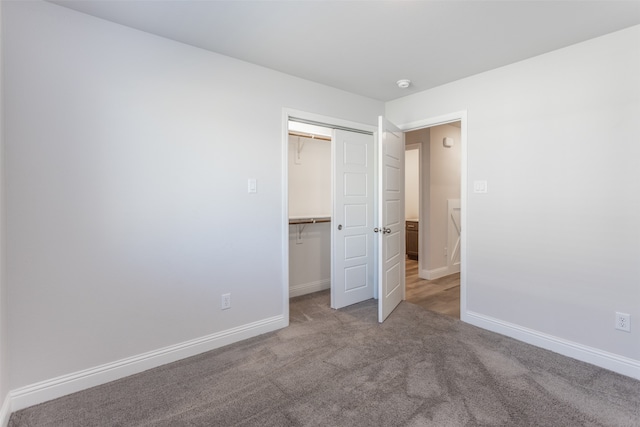 unfurnished bedroom with light carpet and a closet