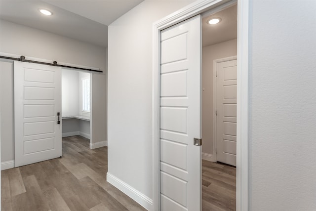 corridor featuring a barn door and light hardwood / wood-style floors