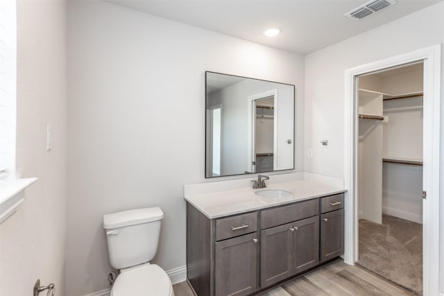 113 Bailey Ranch Dr, Lindsay, TX 76240 - bathroom with toilet, wood finished floors, vanity, a spacious closet, and baseboards