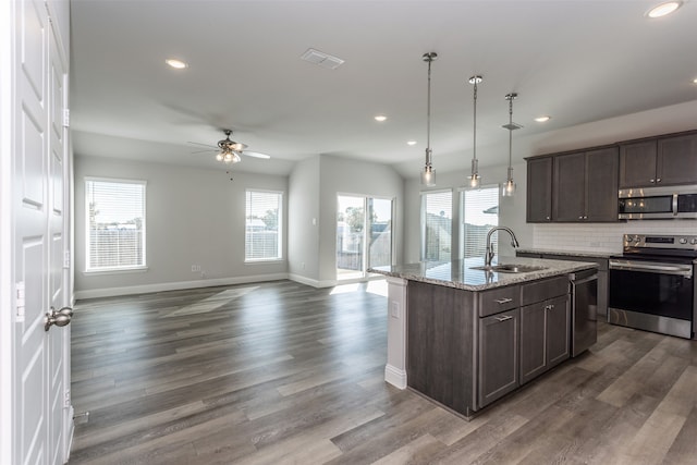 kitchen featuring pendant lighting, an island with sink, stainless steel appliances, and dark hardwood / wood-style flooring