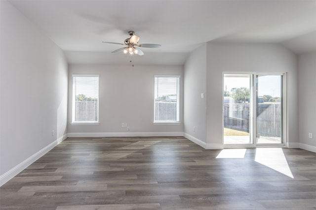 spare room featuring lofted ceiling, dark hardwood / wood-style floors, and plenty of natural light