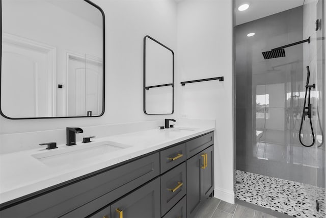 bathroom with a tile shower, hardwood / wood-style floors, and vanity