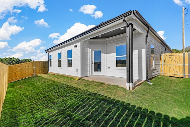 rear view of property featuring a yard and a patio area