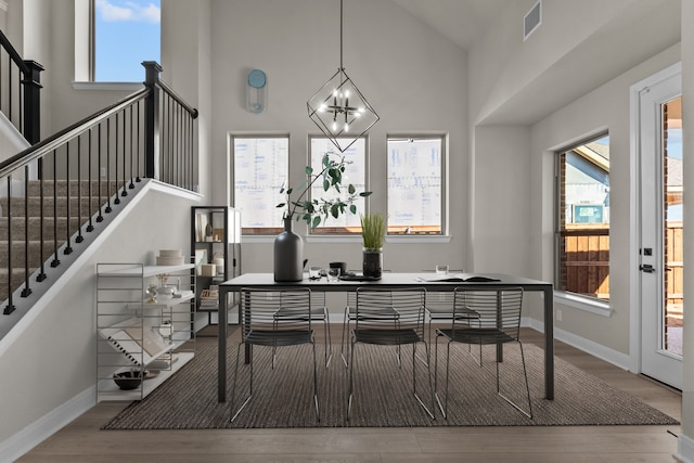 dining room featuring a healthy amount of sunlight, visible vents, baseboards, and wood finished floors