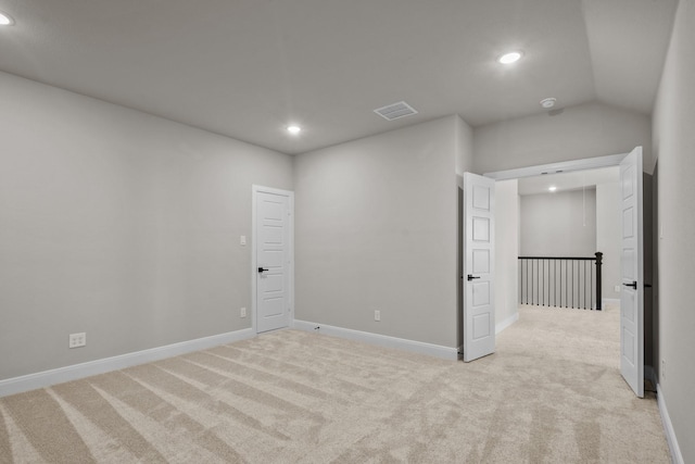 empty room with recessed lighting, light carpet, visible vents, baseboards, and vaulted ceiling