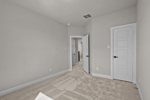 unfurnished bedroom with visible vents, baseboards, and light colored carpet