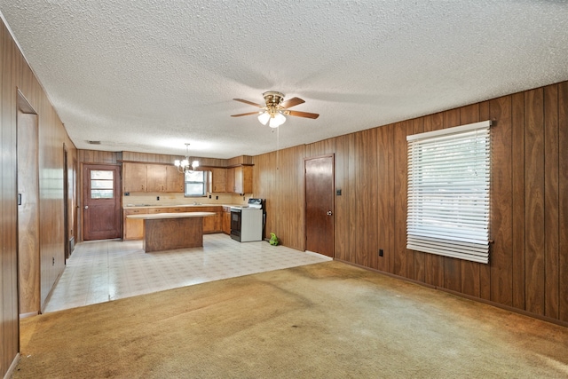 kitchen featuring a kitchen island, a healthy amount of sunlight, hanging light fixtures, and electric stove