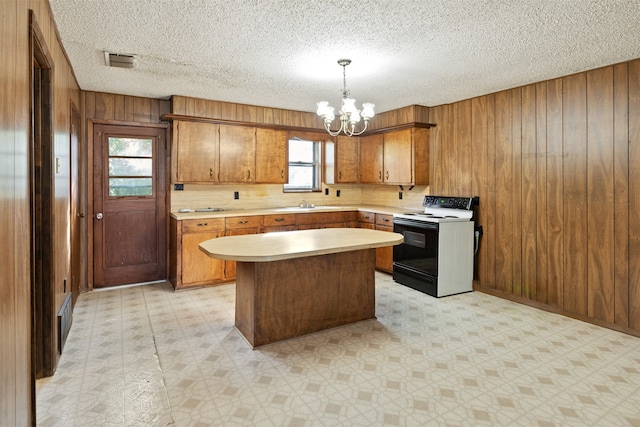 kitchen with a wealth of natural light, a center island, decorative light fixtures, and white electric stove