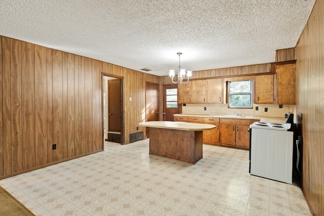 112 Crocker Rd, Malakoff, TX 75148 - kitchen with white electric stove, light countertops, a chandelier, brown cabinets, and light flooring