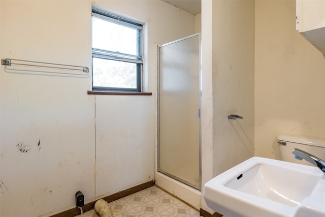 bathroom featuring toilet, walk in shower, and sink